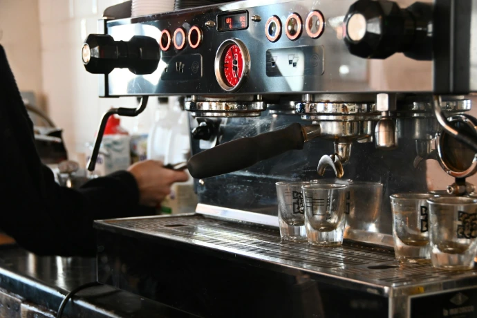 a person pouring a drink into a glass